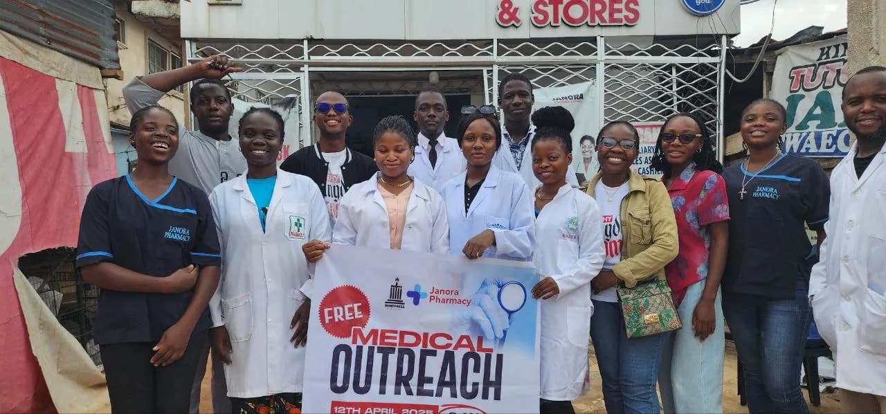 Janora Pharmacy team holding a Free Medical Outreach banner