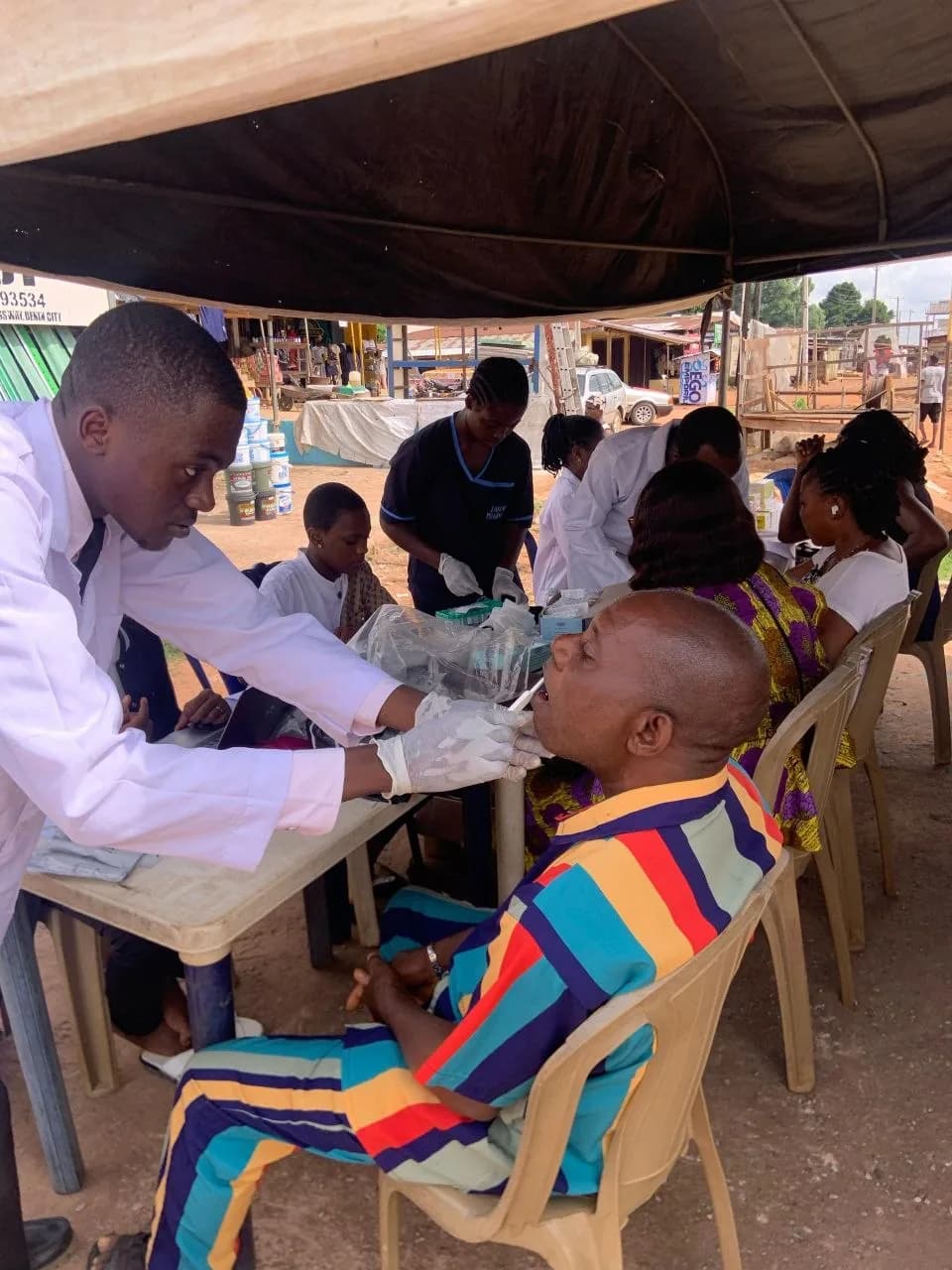 A pharmacist conducting a screening on a male patient